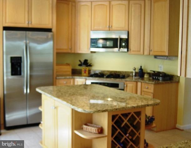 702 Runabout Loop, Unit V10 Solomons, MD 20688 - Photo 26 of 30 a kitchen with stainless steel appliances granite countertop a sink a microwave cabinets and a counter top space