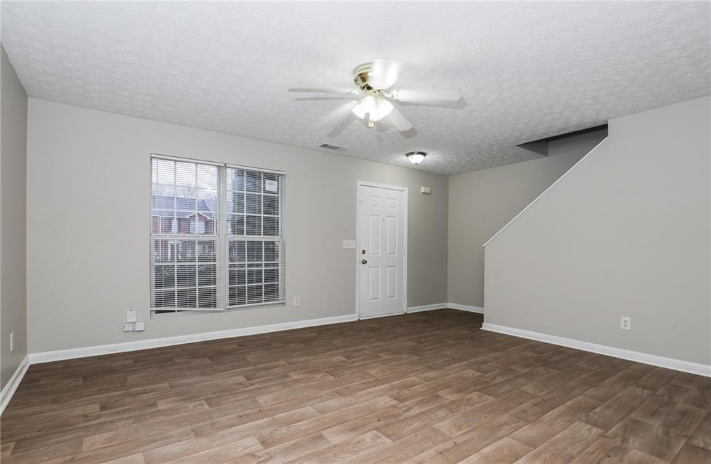 5896 Strathmoor Manor Circle Lithonia, GA 30058 - Photo 2 of 19 a view of an empty room with a window and wooden floor