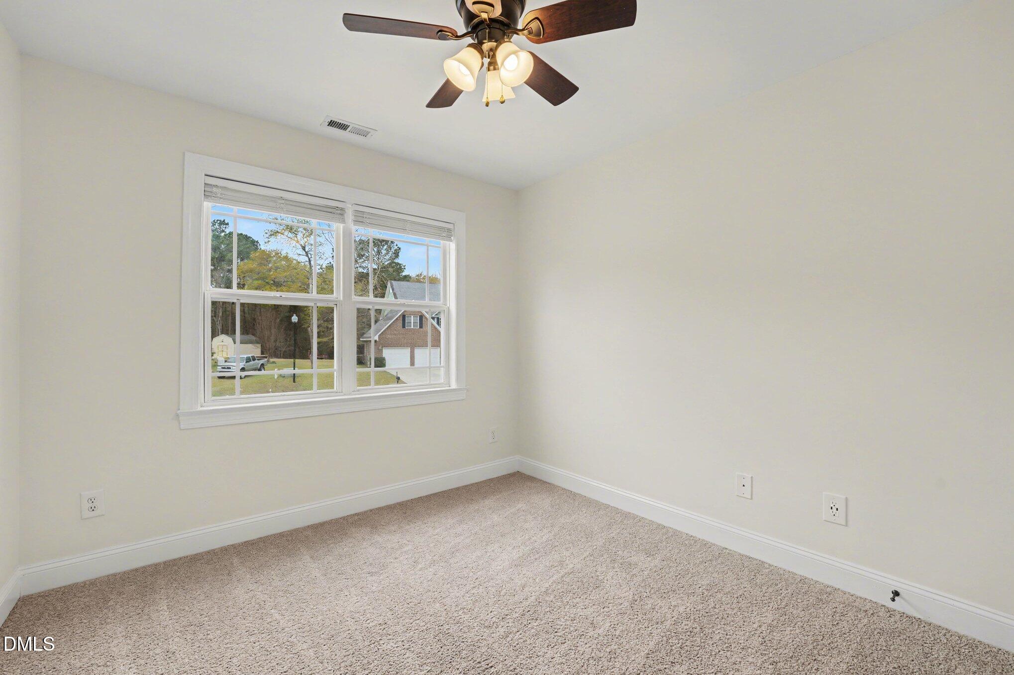 7250 Sandcastle Lane Linden, NC 28356 - Photo 12 of 20 an empty room with chandelier fan and windows