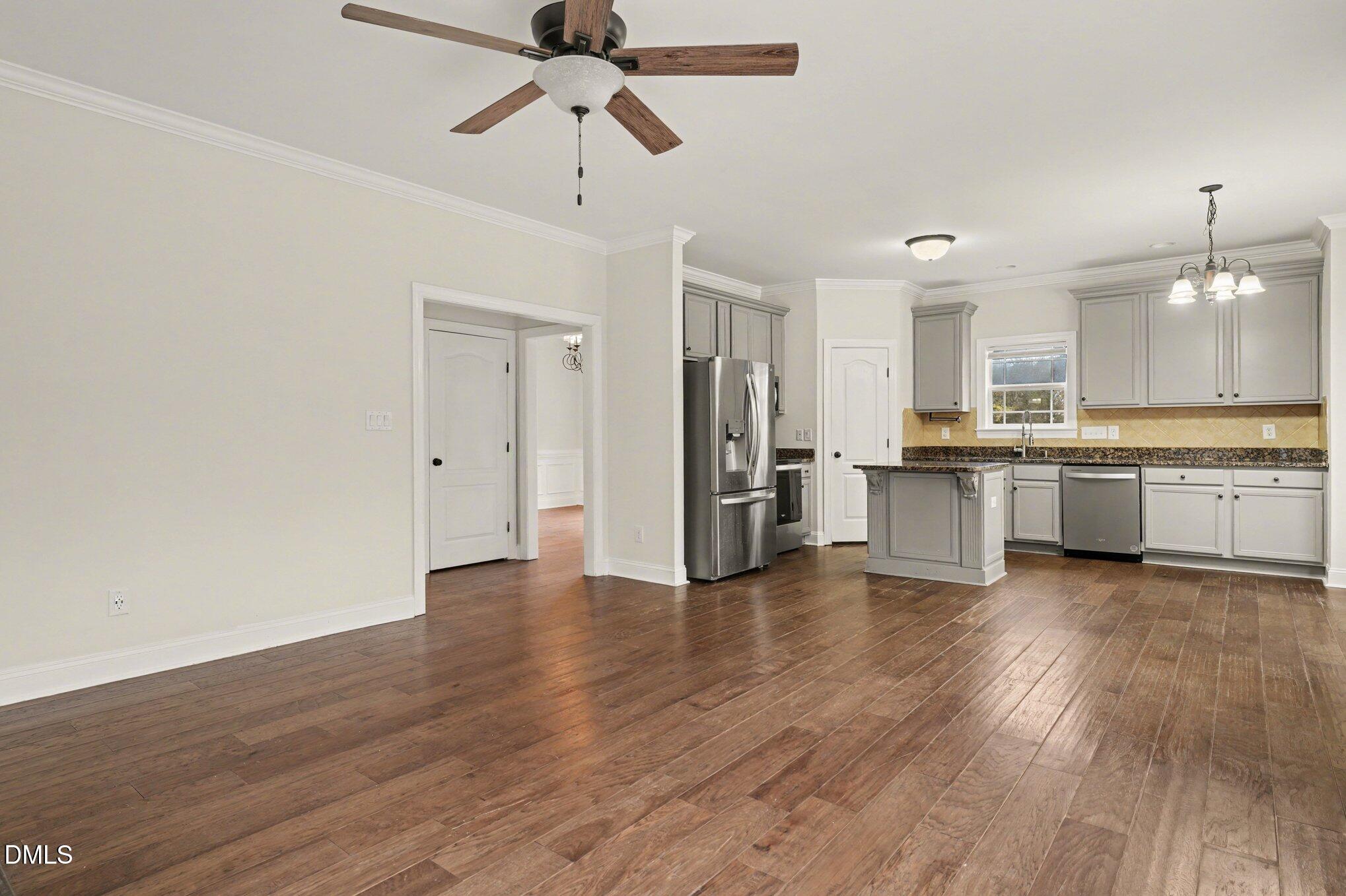 7250 Sandcastle Lane Linden, NC 28356 - Photo 5 of 20 a view of a kitchen with a refrigerator a ceiling fan and wooden floor