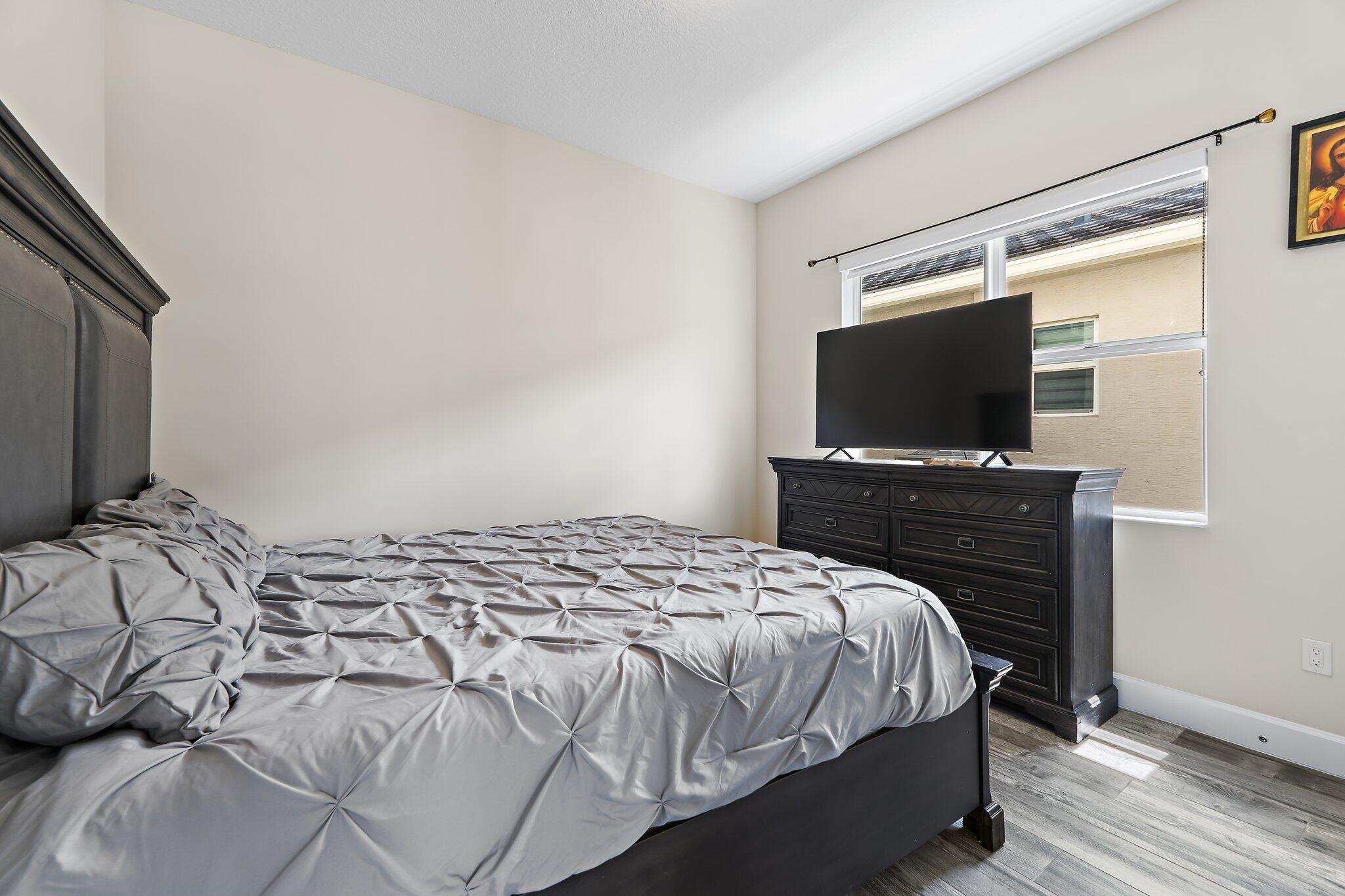 15834 Hummingbird Lane Westlake, FL 33470 - Photo 21 of 61 a bedroom with a bed and a flat screen tv