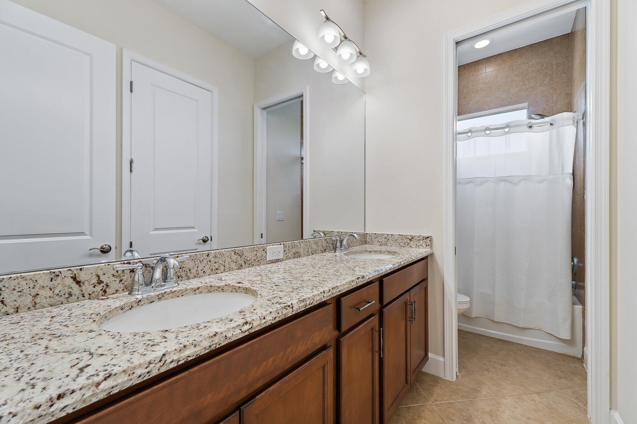 15834 Hummingbird Lane Westlake, FL 33470 - Photo 31 of 61 a bathroom with a granite countertop sink and a mirror