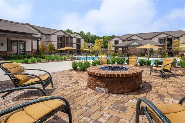 a view of a patio with couches table and chairs and potted plants