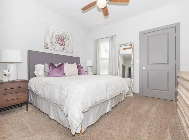 a spacious bedroom with a bed and a painting on the wall