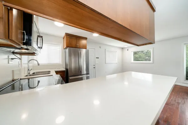 a kitchen with wooden cabinets and a wooden floor