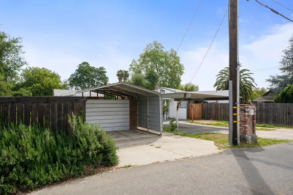 a palm tree sitting in front of a house with a yard