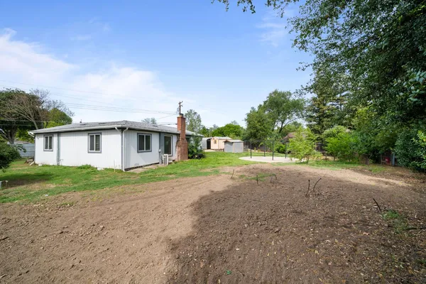 a view of a house with a yard and potted plants