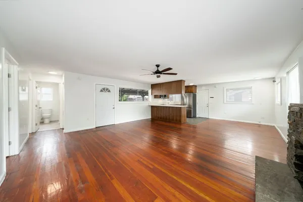 a view of a livingroom with wooden floor and a ceiling fan