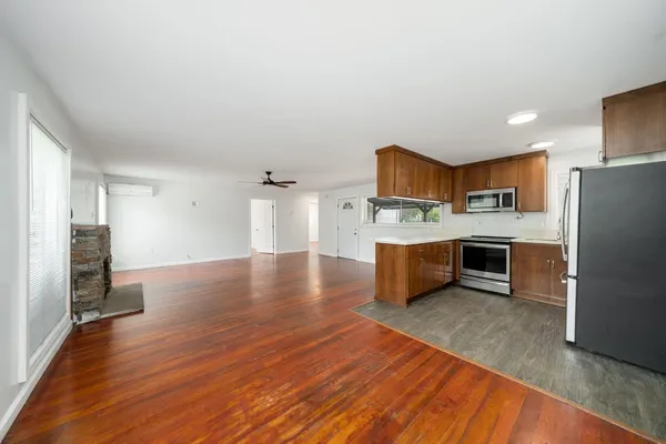 a open kitchen with cabinets wooden floor and stainless steel appliances
