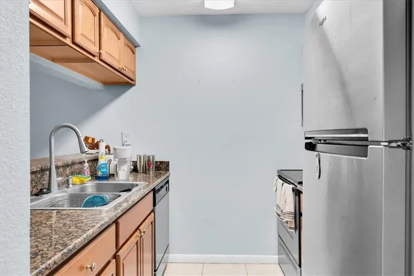 a kitchen with a sink a refrigerator and cabinets
