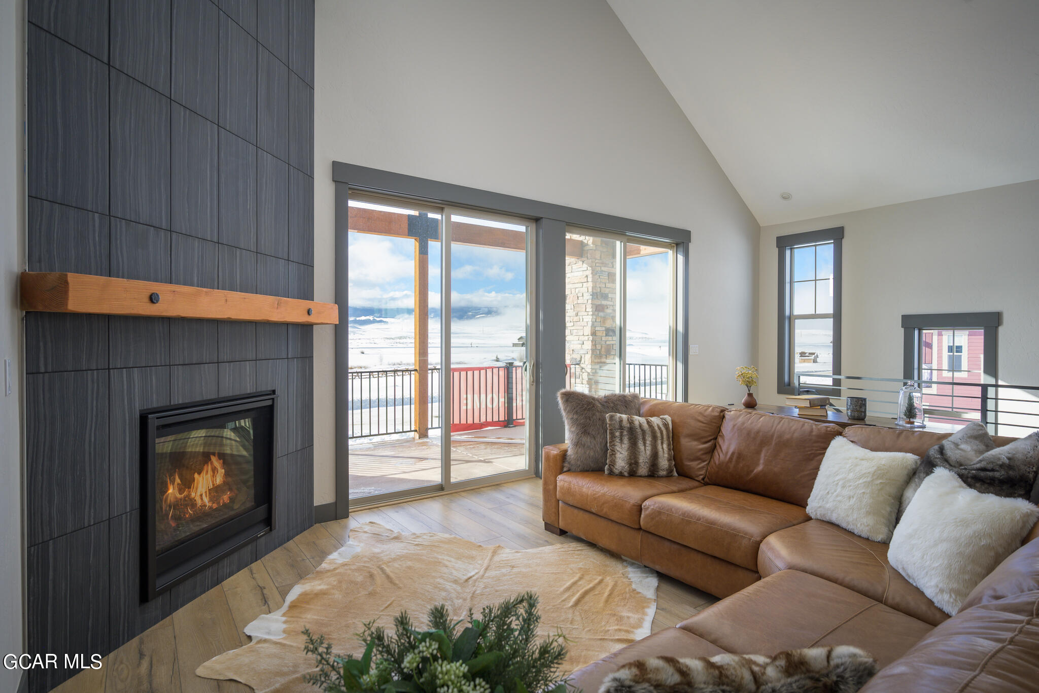 a living room with furniture a flat screen tv and a fireplace