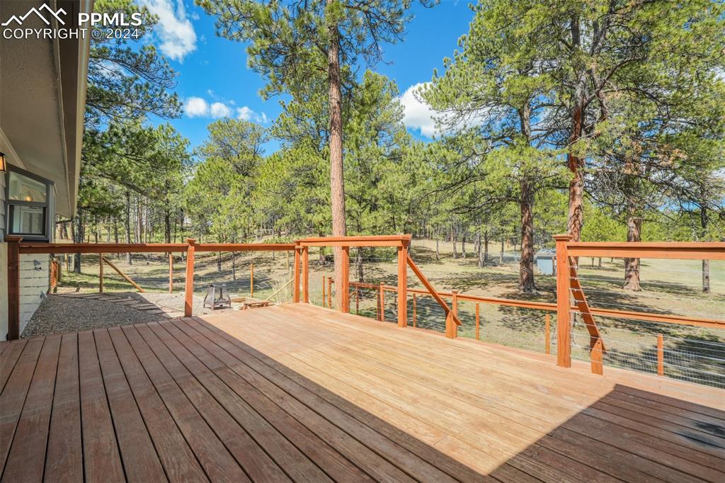 8950 Pine Cone Road Colorado Springs, CO 80908 - Photo 32 of 47 a view of a balcony with wooden floor and outdoor seating