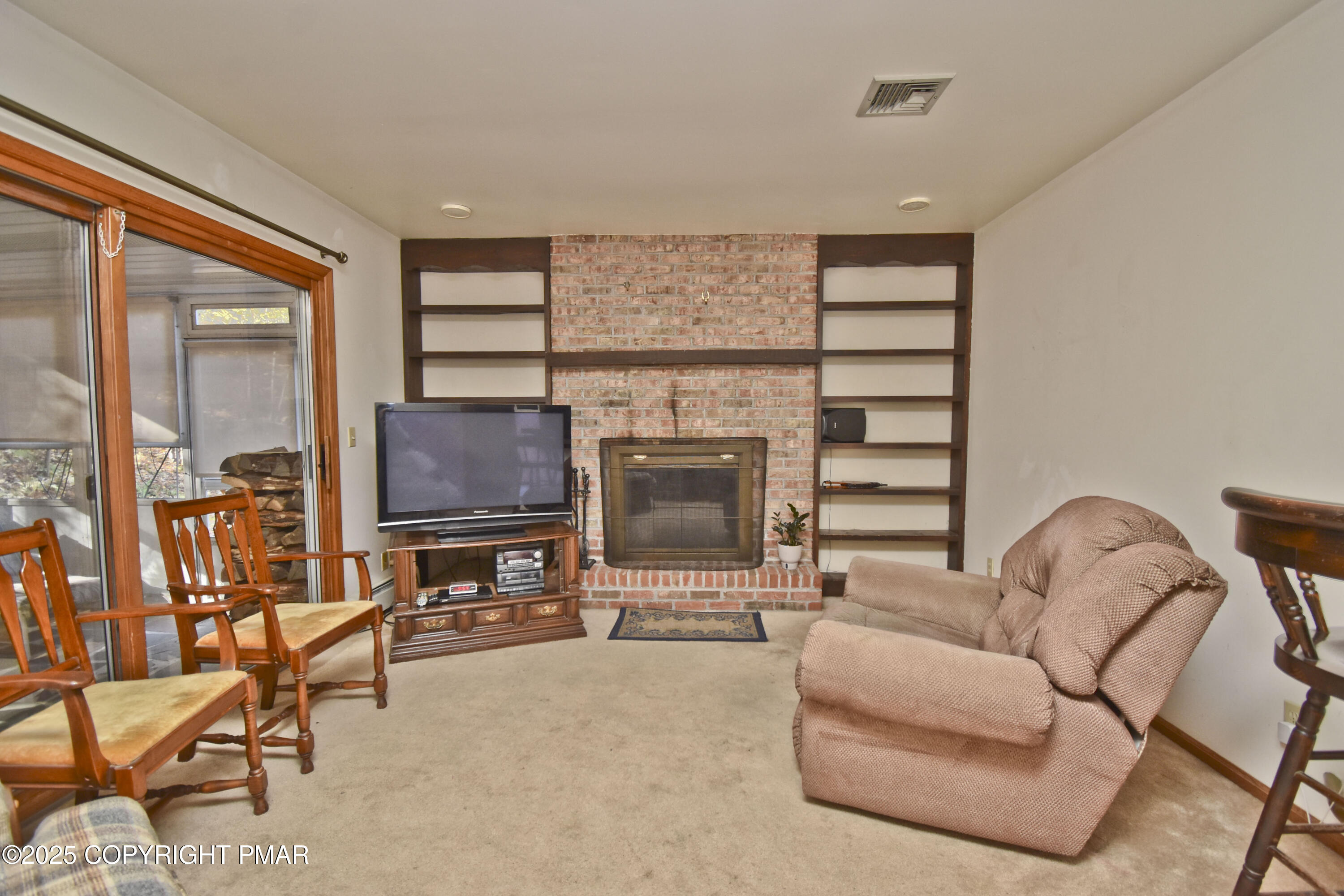 5294 Cherry Valley Road Saylorsburg, PA 18353 - Photo 11 of 53 a living room with furniture a flat screen tv and a floor to ceiling window
