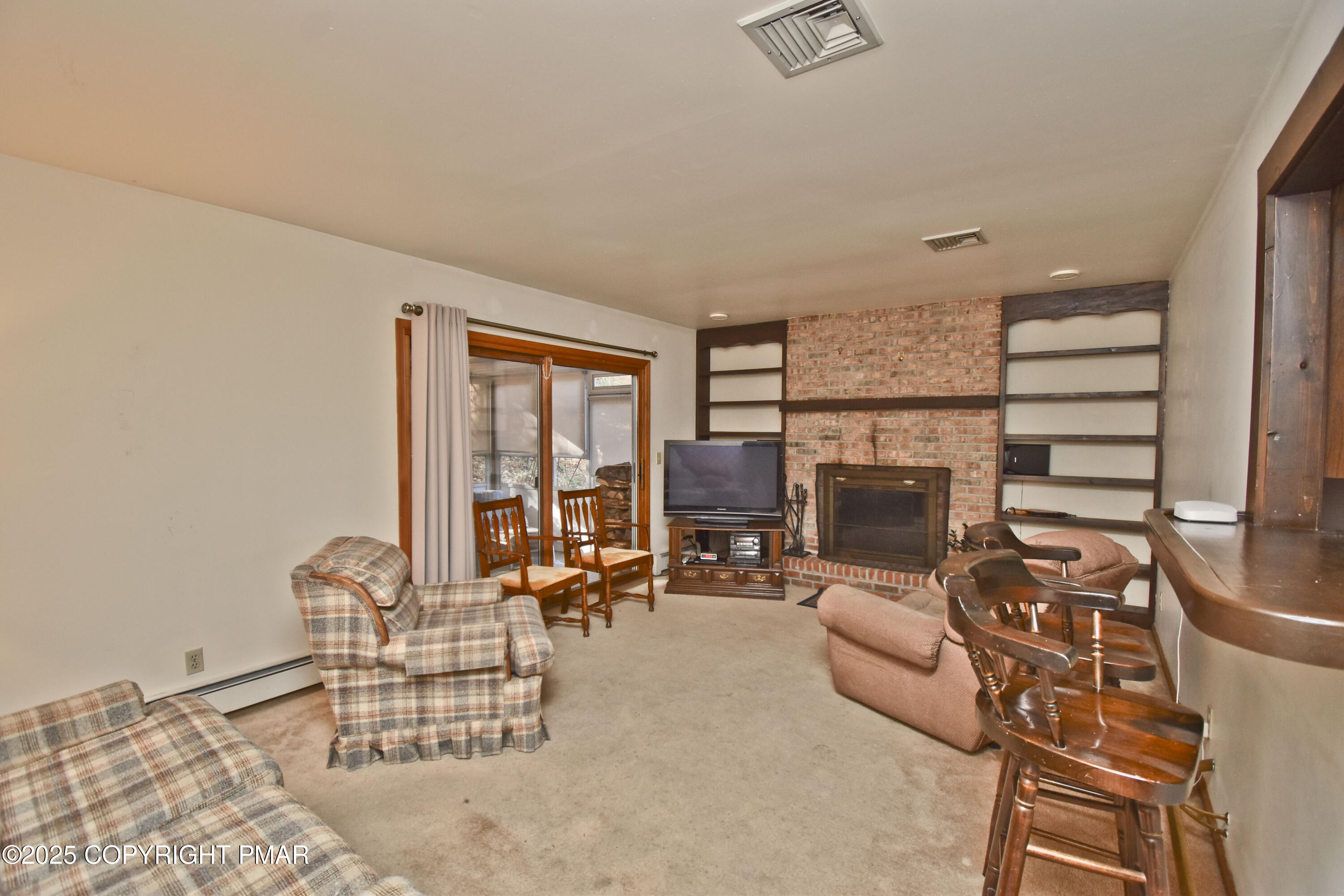 5294 Cherry Valley Road Saylorsburg, PA 18353 - Photo 10 of 53 a living room with furniture a fireplace and a floor to ceiling window