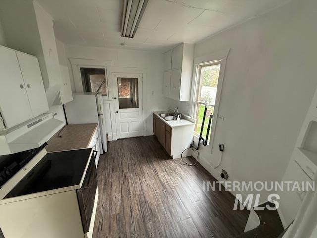 204 Front Street Kooskia, ID 83539 - Photo 11 of 25 Kitchen featuring white cabinetry, electric stove, freestanding refrigerator, and dark wood finished floors