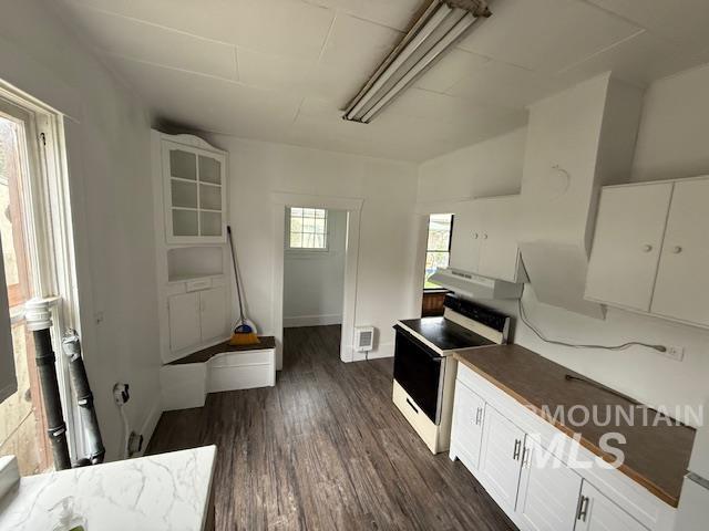 204 Front Street Kooskia, ID 83539 - Photo 12 of 25 Kitchen featuring white cabinets, range with electric cooktop, and dark wood-style floors