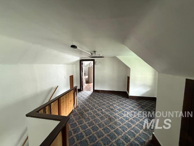 204 Front Street Kooskia, ID 83539 - Photo 19 of 25 Additional living space featuring vaulted ceiling and dark carpet
