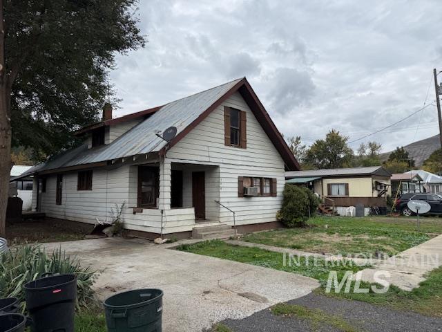 204 Front Street Kooskia, ID 83539 - Photo 2 of 25 Bungalow with a chimney, a metal roof, a front lawn, and cooling unit