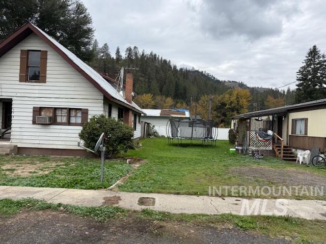 204 Front Street Kooskia, ID 83539 - Photo 5 of 25 View of home's exterior featuring a trampoline, a yard, and a chimney