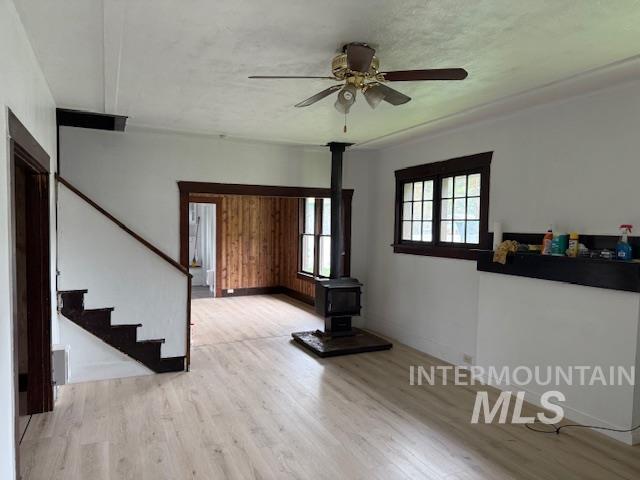 204 Front Street Kooskia, ID 83539 - Photo 6 of 25 Unfurnished living room with a wood stove, light wood-style floors, stairway, and ceiling fan