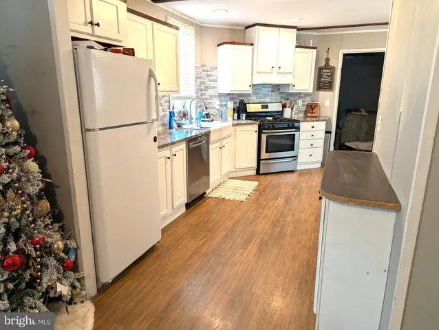 a kitchen with white cabinets and white appliances