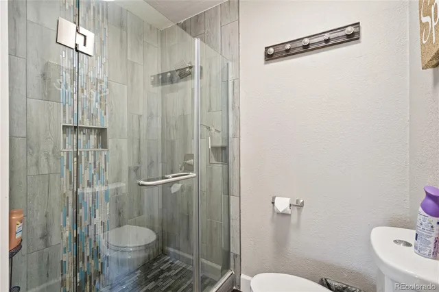 a bathroom with a toilet and a shower
