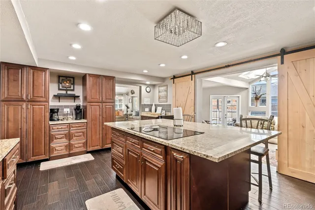 a kitchen with stainless steel appliances granite countertop a sink and dishwasher a refrigerator with wooden floor
