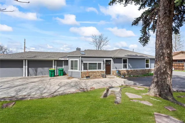a front view of a house with a garden and yard
