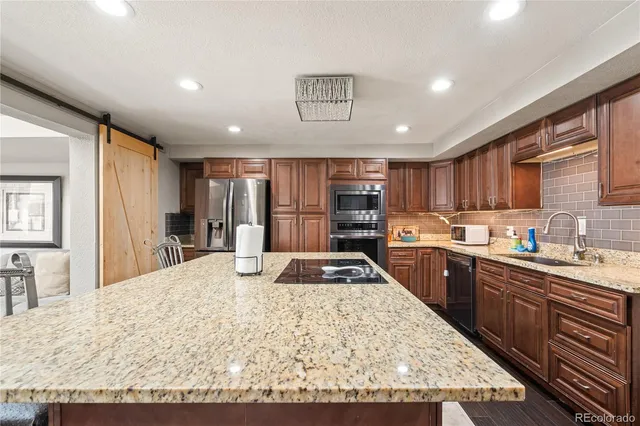 a kitchen with stainless steel appliances granite countertop a sink stove and a refrigerator