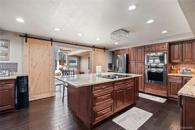 a kitchen with stainless steel appliances granite countertop a stove and a refrigerator