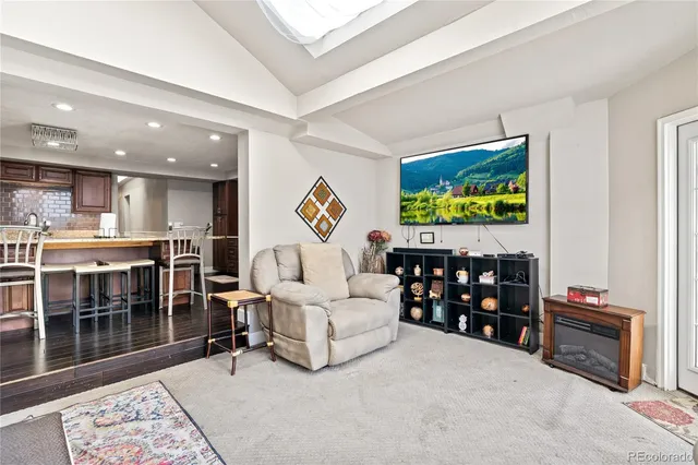 a living room with furniture a flat screen tv and floor to ceiling window