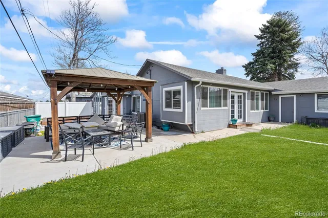 a view of a patio with table and chairs with plants and garden