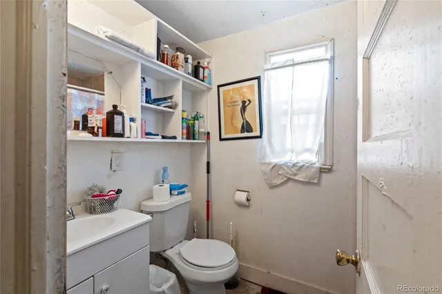 a bathroom with a toilet a sink and a window