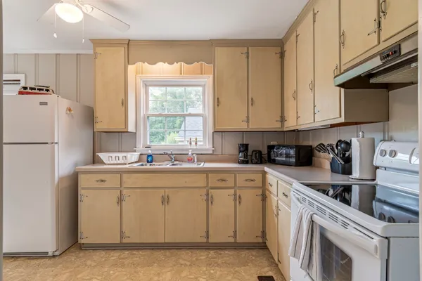 a kitchen with cabinets appliances a sink and a window