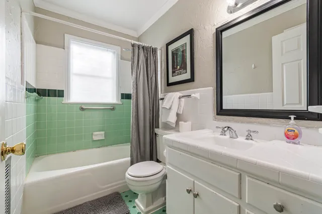 a bathroom with a sink a toilet a mirror and shower