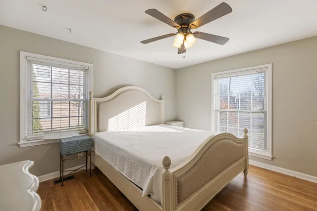 a bedroom with a bed next to a window with a chandelier