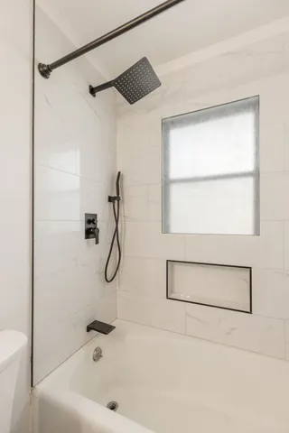 a bathroom with a bath tub with a shower