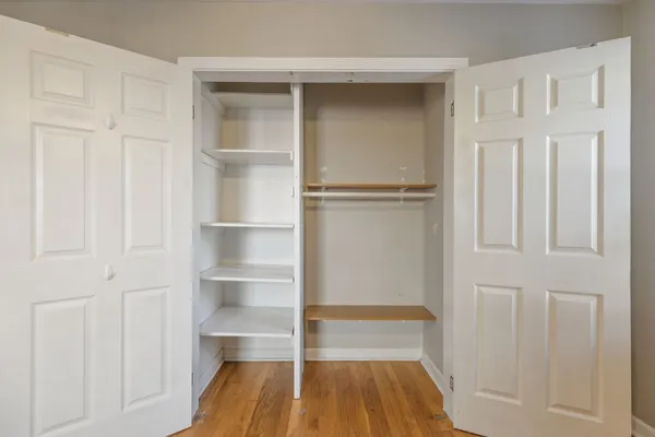 a view of walk in closet with empty racks