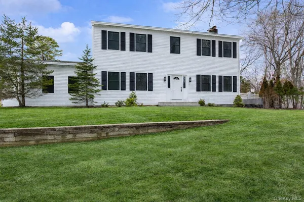 a front view of a house with a yard and trees