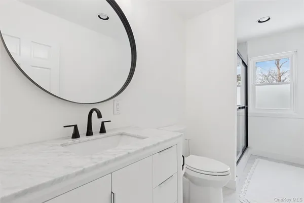 a bathroom with a toilet sink and mirror