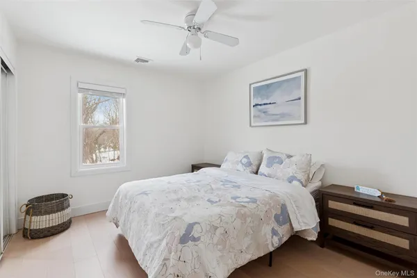 a bedroom with a bed and a painting on the wall