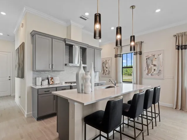 a kitchen with a dining table chairs and cabinets