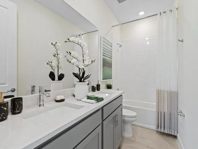 a bathroom with a double vanity sink toilet and shower