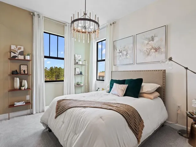 a bedroom with a large bed and a chandelier