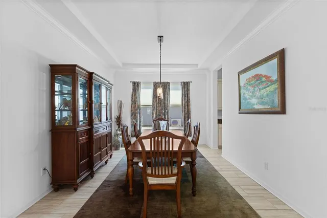 a dining room with furniture a chandelier and wooden floor