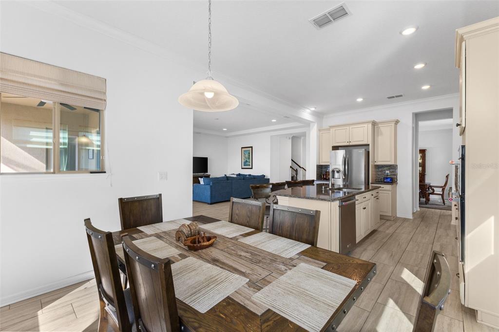13065 Bliss Loop Bradenton, FL 34211 - Photo 14 of 54 a view of a dining room and livingroom with furniture wooden floor a rug a flat screen tv a rug and a chandelier