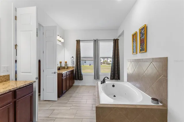 a bathroom with a tub sink and mirror