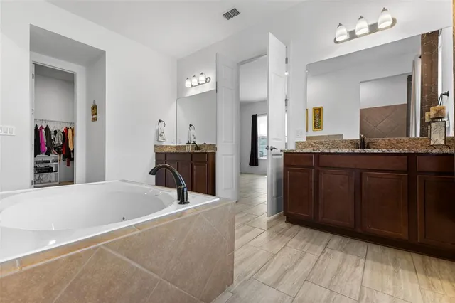 a bathroom with a tub sink and mirror