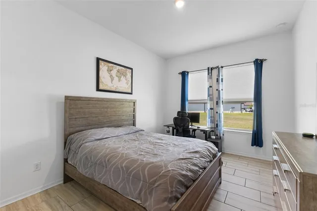 a bedroom with a bed and a painting on the wall