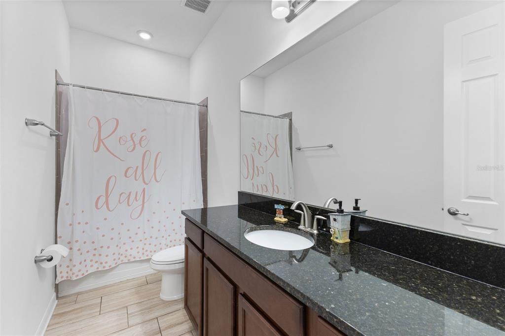 13065 Bliss Loop Bradenton, FL 34211 - Photo 28 of 54 a bathroom with a granite countertop sink toilet and shower